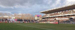 Imagen del estadio y tifo en el fondo